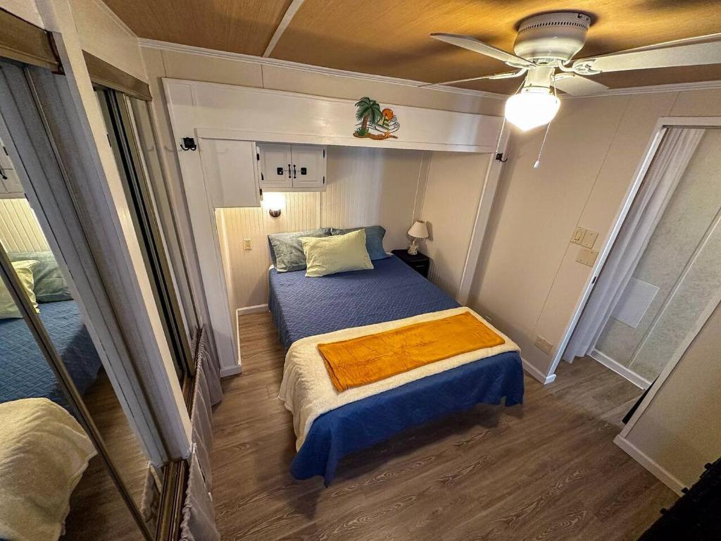 a small bedroom with a bed and a ceiling fan at The Salty Camper in North Topsail Beach