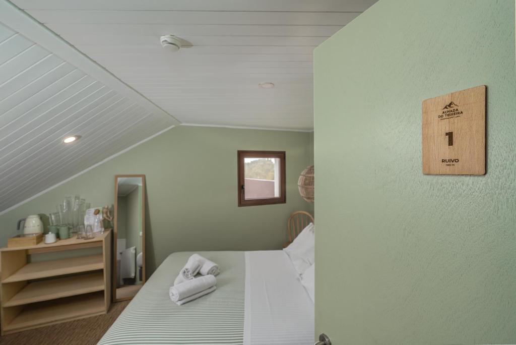 a bedroom with a bed with towels on it at Achada do Teixeira Mountain Spot Lodge in Santana
