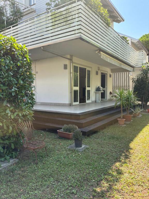 a porch of a house with a bench and plants at Casa con giardino in Cervia