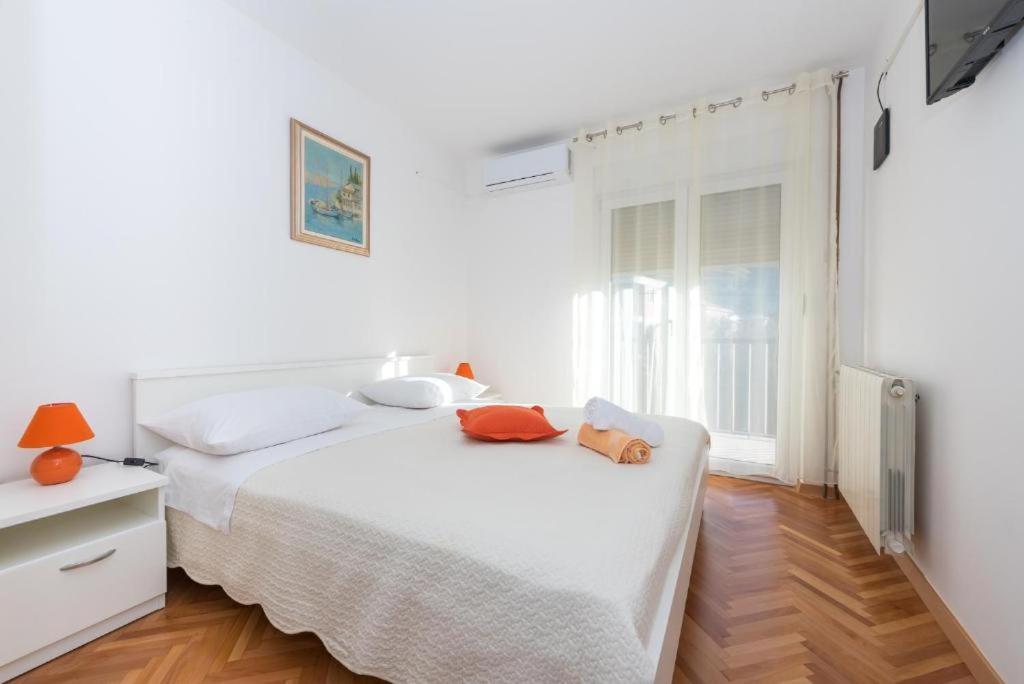 a white bedroom with a bed and a window at Room Peričić in Strožanac