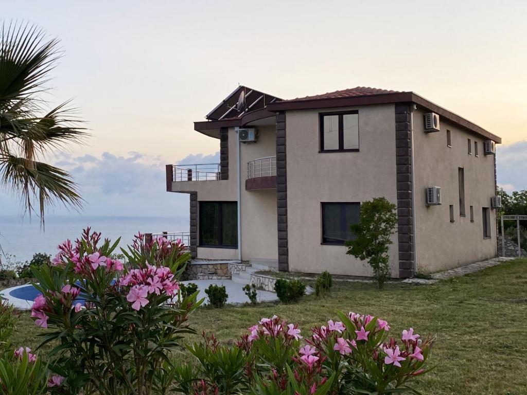 a house with pink flowers in front of it at Villa 11 Infinity pool & garden in Dobra Voda
