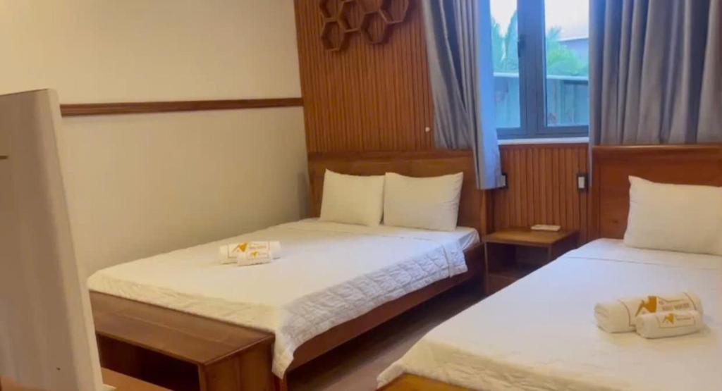 a hotel room with two beds and a window at Sao Biển Phú Quốc in Phú Quốc