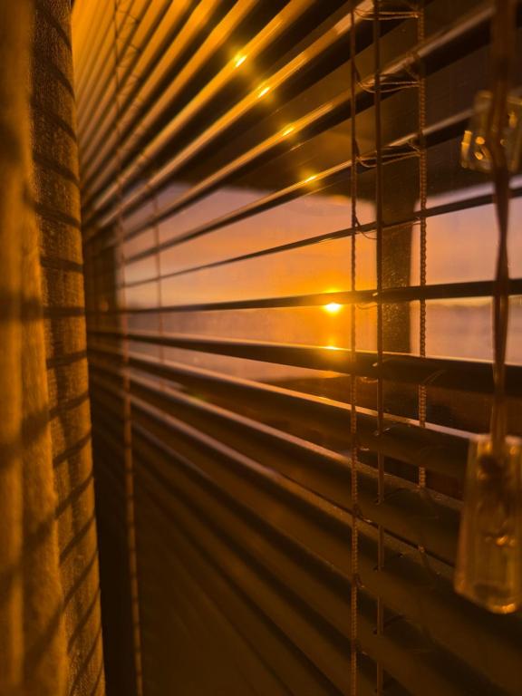 a sunset seen through the blinds of a window at Villa Kiara in Vodice