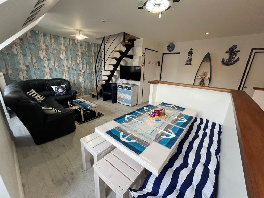 a living room with a table and a couch at Les Roitelets "MARINE" Appartement T4 Duplex 80m2 - Thème Marin - Entièrement NEUF - Classé 3 étoiles - Proche Centre-ville & Thermes - Tout Confort - Ménage et Linge de maison INCLUS in La Bourboule