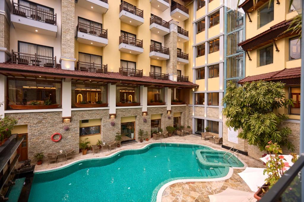 an apartment building with a swimming pool in the courtyard at Temple Bell Boutique Hotel & Spa in Pokhara