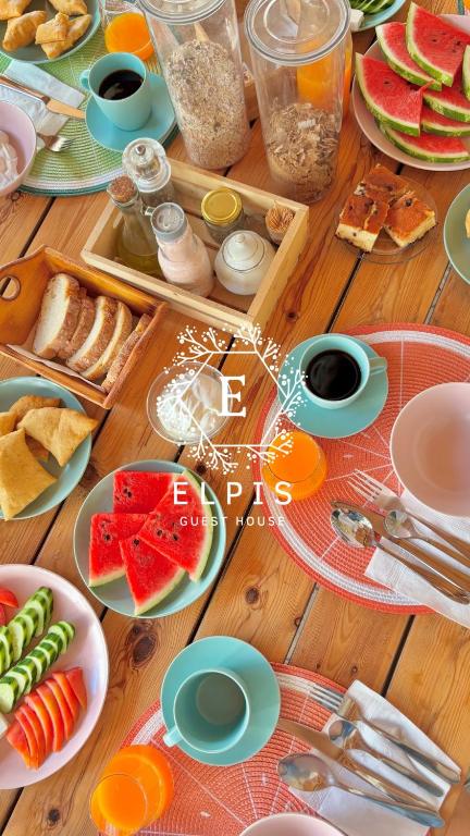 a table topped with plates of food and fruit at Elpis Guest House in Himare