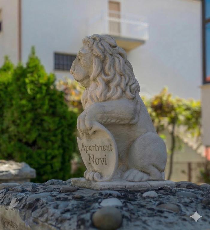 a stone statue of a lion holding a sign at Apartment Novi II in Kaštela
