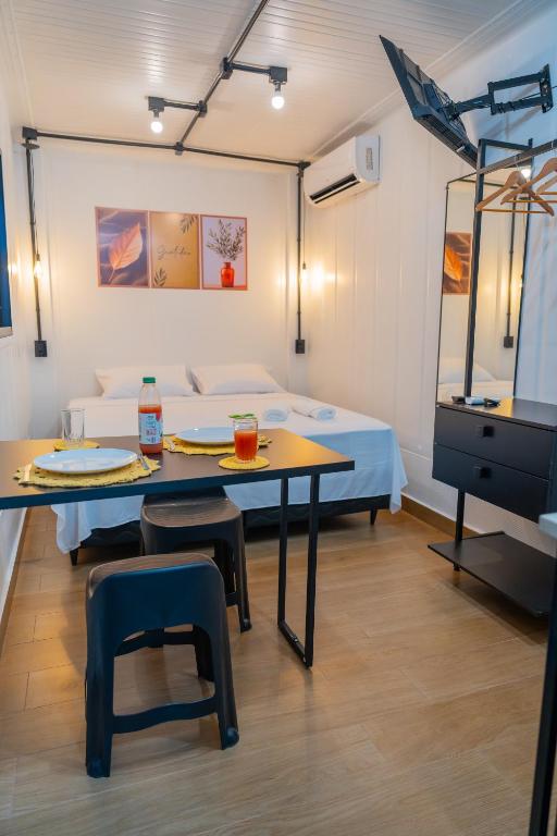 a room with a bed and a table and chairs at Studio Container - Conforto e Ótima Localização in Sinop