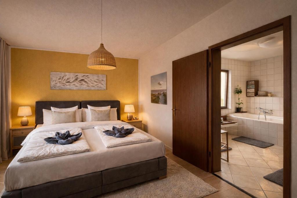 a bedroom with a bed and a bathroom with a tub at Ferienhaus ,,Pier 7" am See - 2 Wohnungen mit Garten für bis zu 11 Personen, einzeln oder zusammen buchbar in Große Mühle