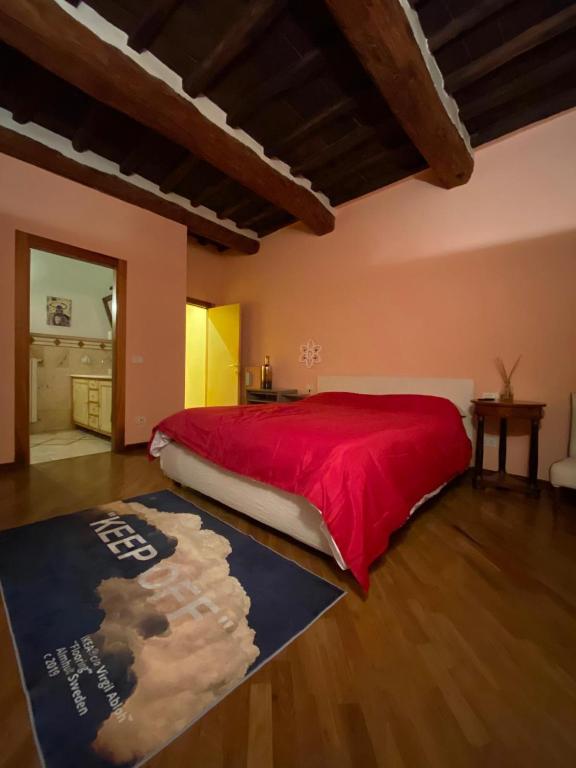 a bedroom with a red bed with a red blanket at la casa d'oro in Arezzo