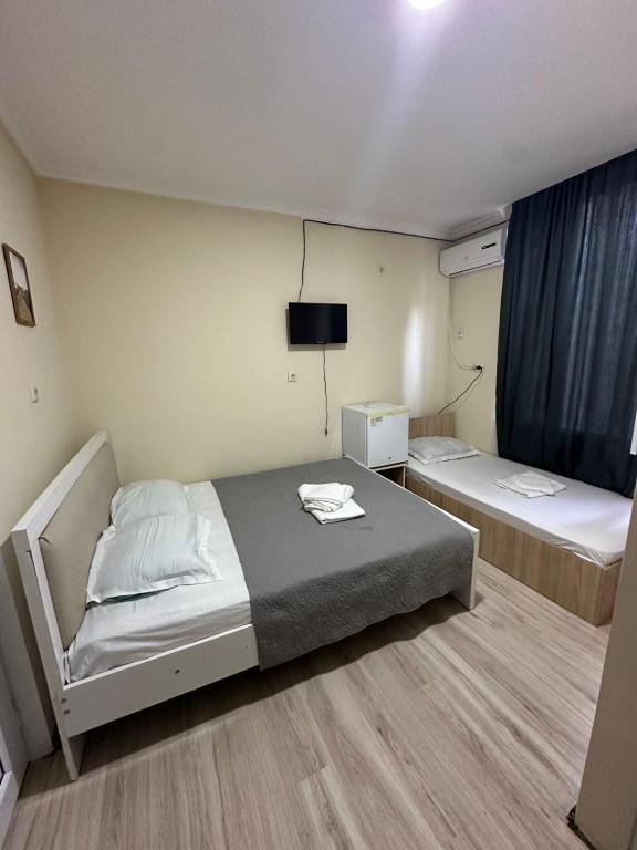 a room with two beds and a television in it at Barakat Hotel in Ureki
