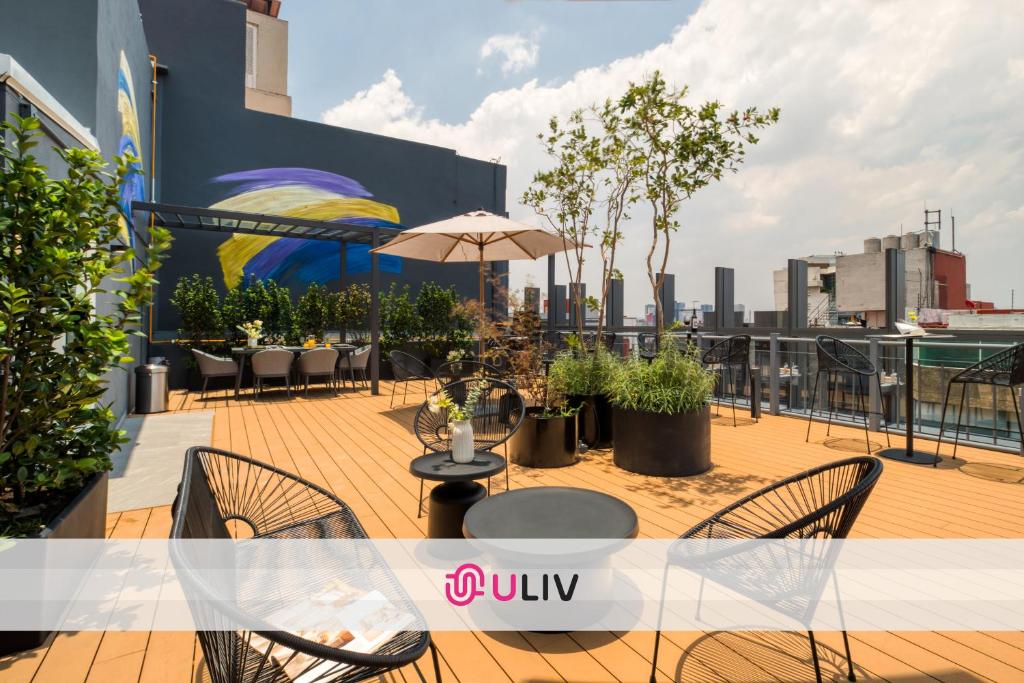 a balcony with tables and chairs on a building at ULIV Parque Lincoln in Mexico City