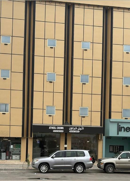 two cars parked in front of a building at شقق أثيل كراون المخدومة in Hafr Al-Batin
