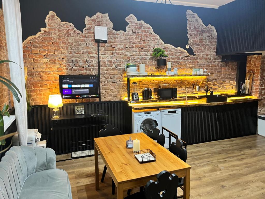 a living room with a table and a brick wall at Agro Bieszczady Sleep Tourism in Czarna