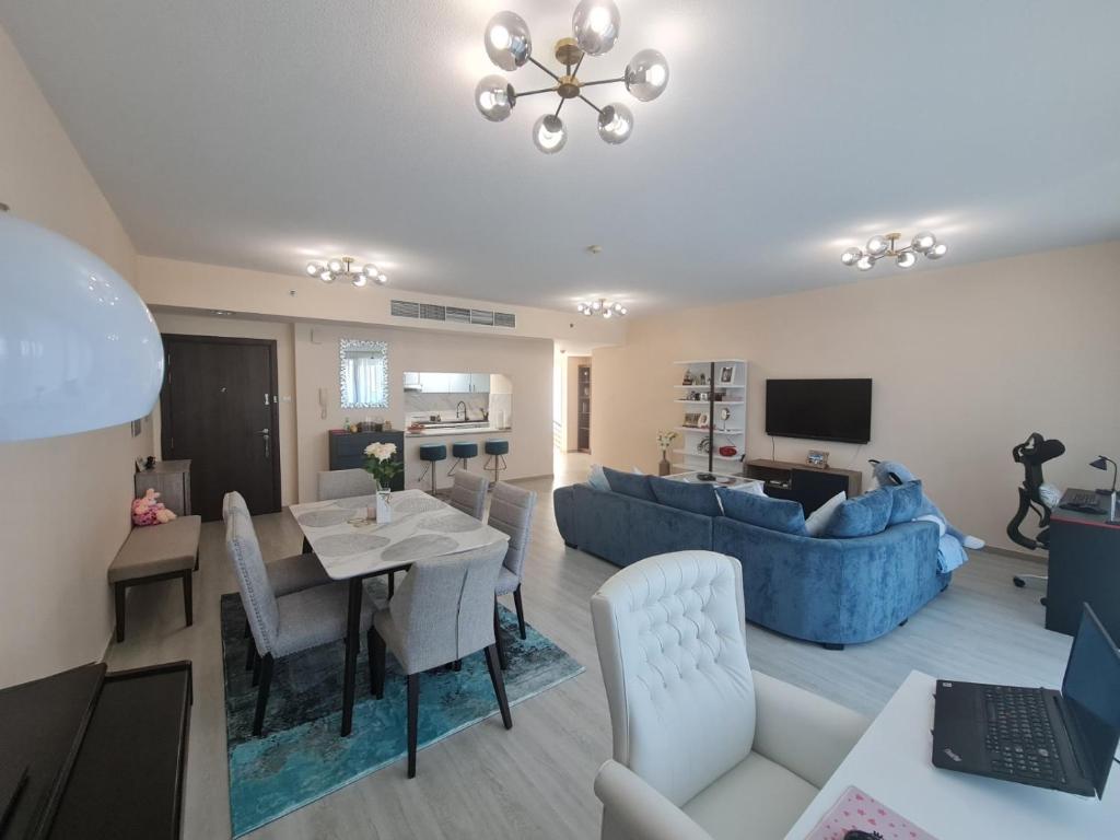 a living room with a table and a blue couch at Belstay2 in Ras al Khaimah