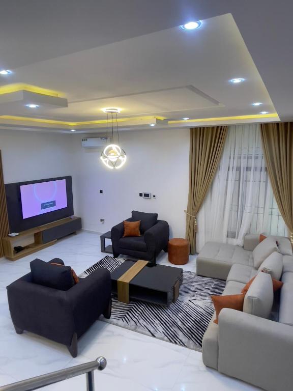 a living room with couches and a flat screen tv at Luxury Four Bedroom Duplex in Asokoro Abuja in a Secure Estate with Fast WiFi & 24hours Electricity in Asokoro