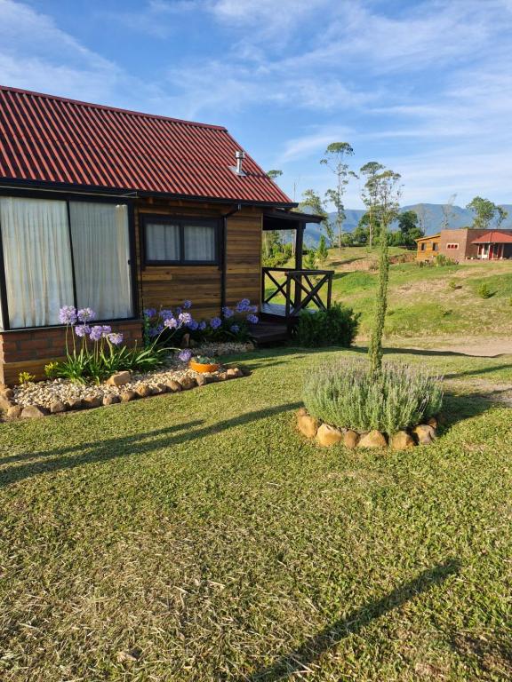 a log cabin with a garden in front of it at Cabana Davos in Timbe do Sul