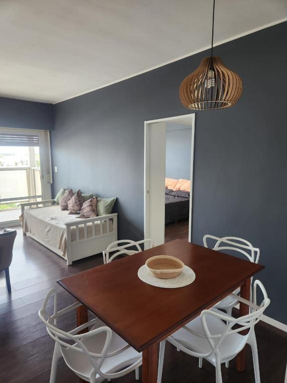 a dining room with a table and a bedroom at Apart Rucapel in General Roca
