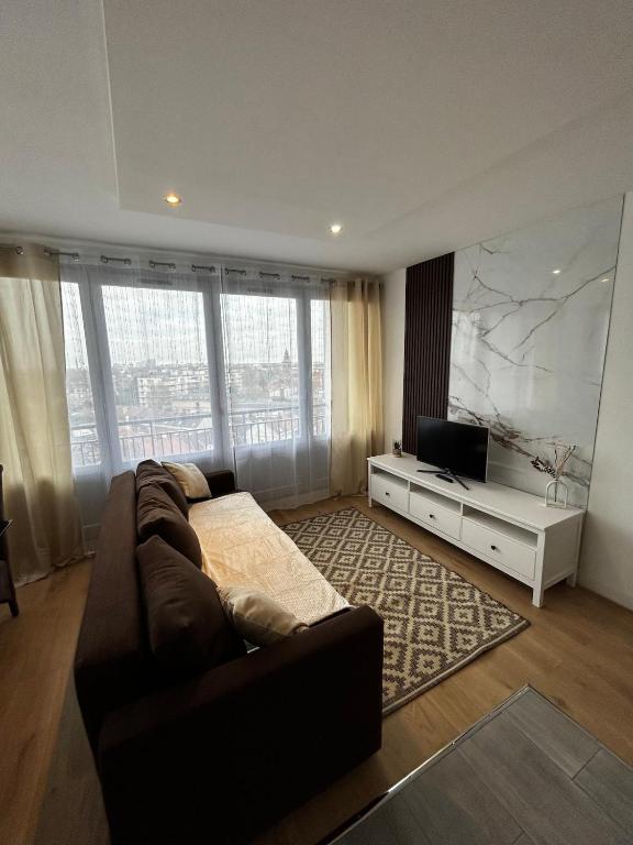a living room with a couch and a television at apartment with balcony in Ronchin