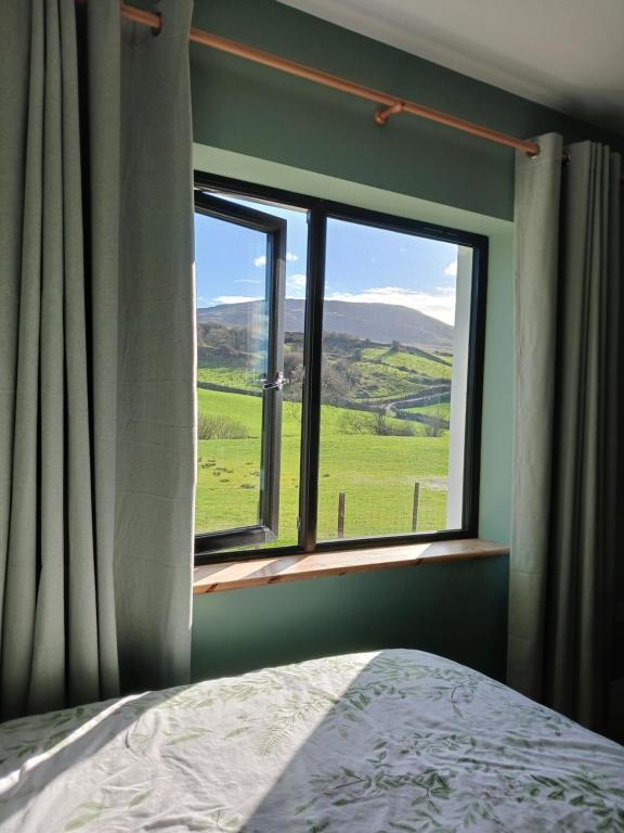 a bedroom with a window with a view of a green field at Mountain hideaway in Finny