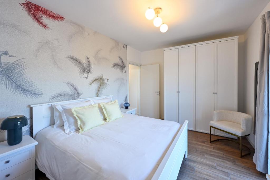 a bedroom with a white bed with a painting on the wall at Lora Luxury Suite 6 ,free private parking, self check in, air conditioner in Como