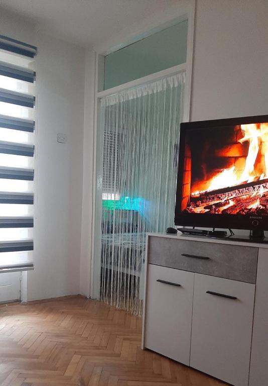 a living room with a flat screen tv on a cabinet at Apartman Suva reka in Leskovac