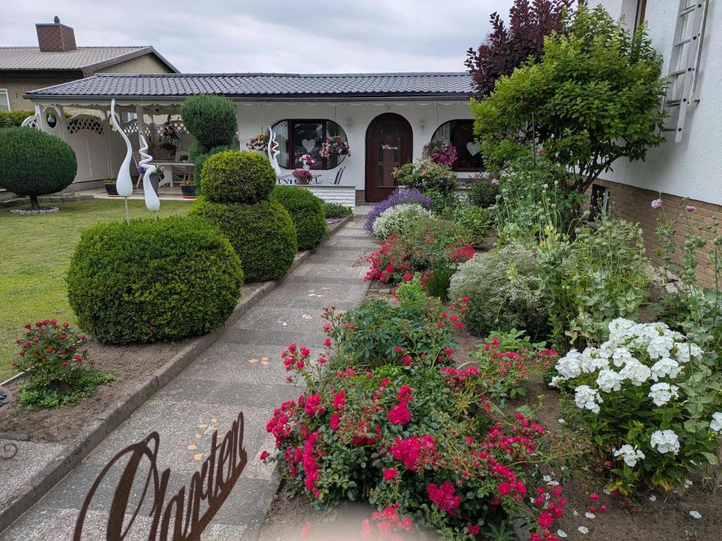 a garden in front of a house with flowers at Charmanter Bungalow in Neubukow nahe der Ostsee in Neubukow