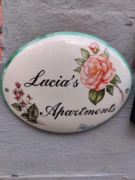 a plate with a flower on it hanging on a wall at Lucia Appartamenti in Ischia Town
