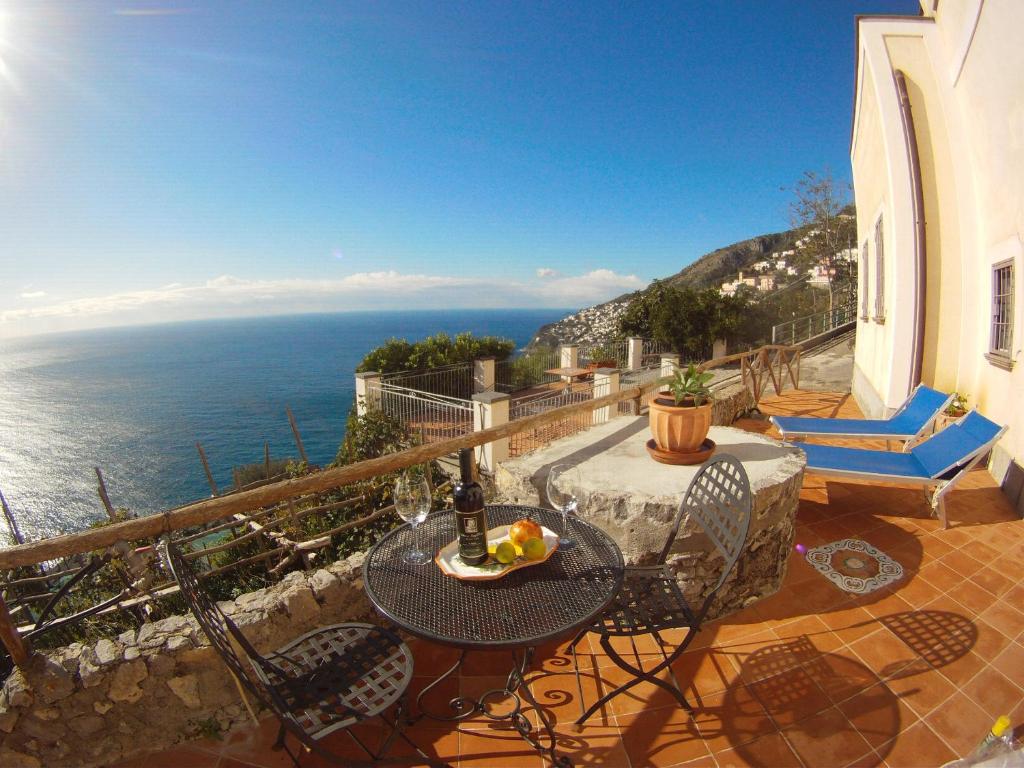 a balcony with a table and chairs and the ocean at Il Limoneto in Furore