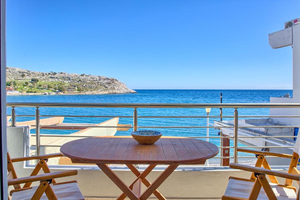 a table on a balcony with a view of the ocean at Haraki Aqua Marine in Haraki