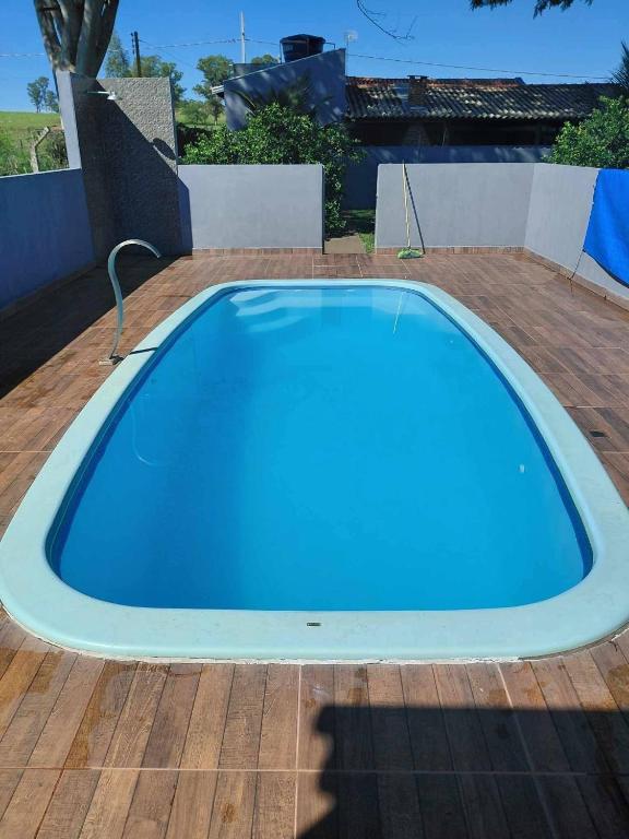 a large blue swimming pool on a wooden deck at Estância arco iris in Regente Feijó