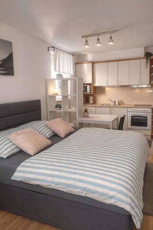 a bedroom with a large bed and a kitchen at Apartmán U Onky in Luhačovice