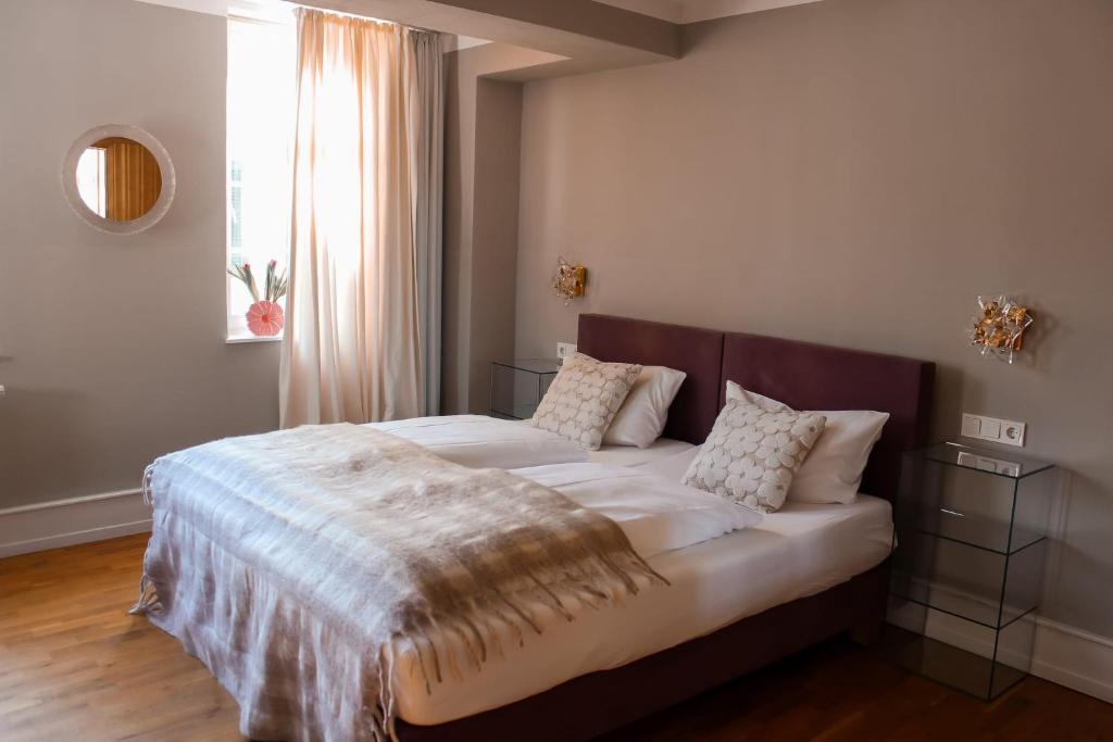 a bedroom with a bed with a blanket on it at Quartier im Eltvinum in Eltville