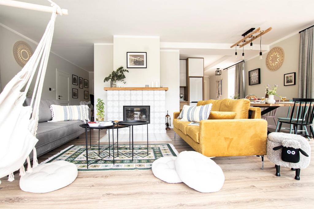 a living room with a yellow couch and a fireplace at Ostoya Skalanka KDN in Zwardoń
