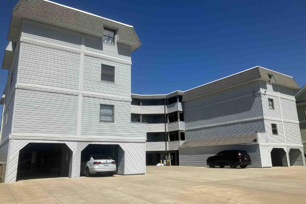 a large building with a car parked in front of it at Salty Paws II in Kill Devil Hills