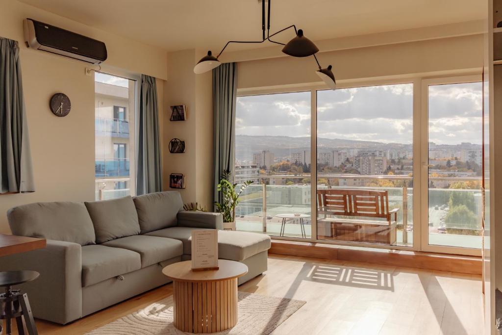 a living room with a couch and a large window at ZEN Rezidential Apartments in Cluj-Napoca
