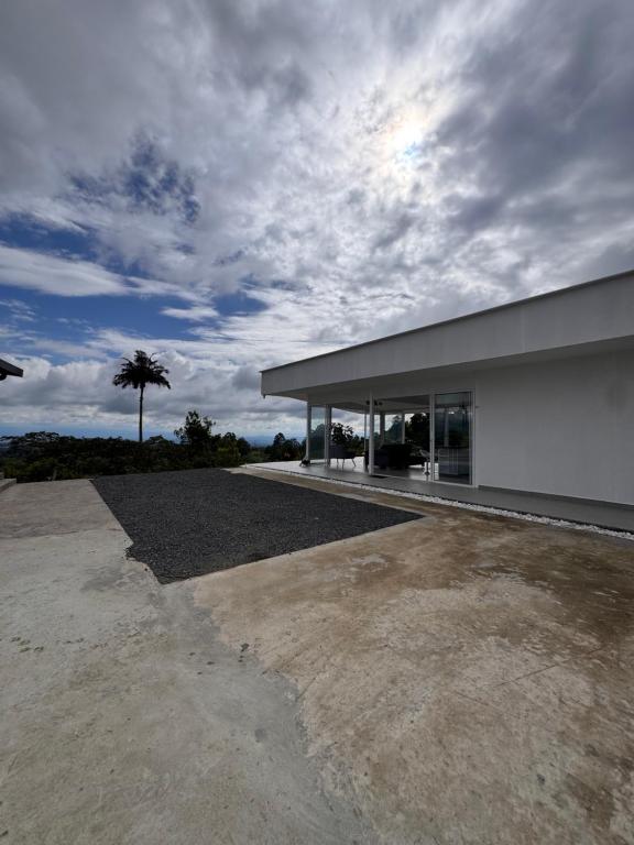 a large white building with a palm tree in the background at casa campestre la daniela in Filandia