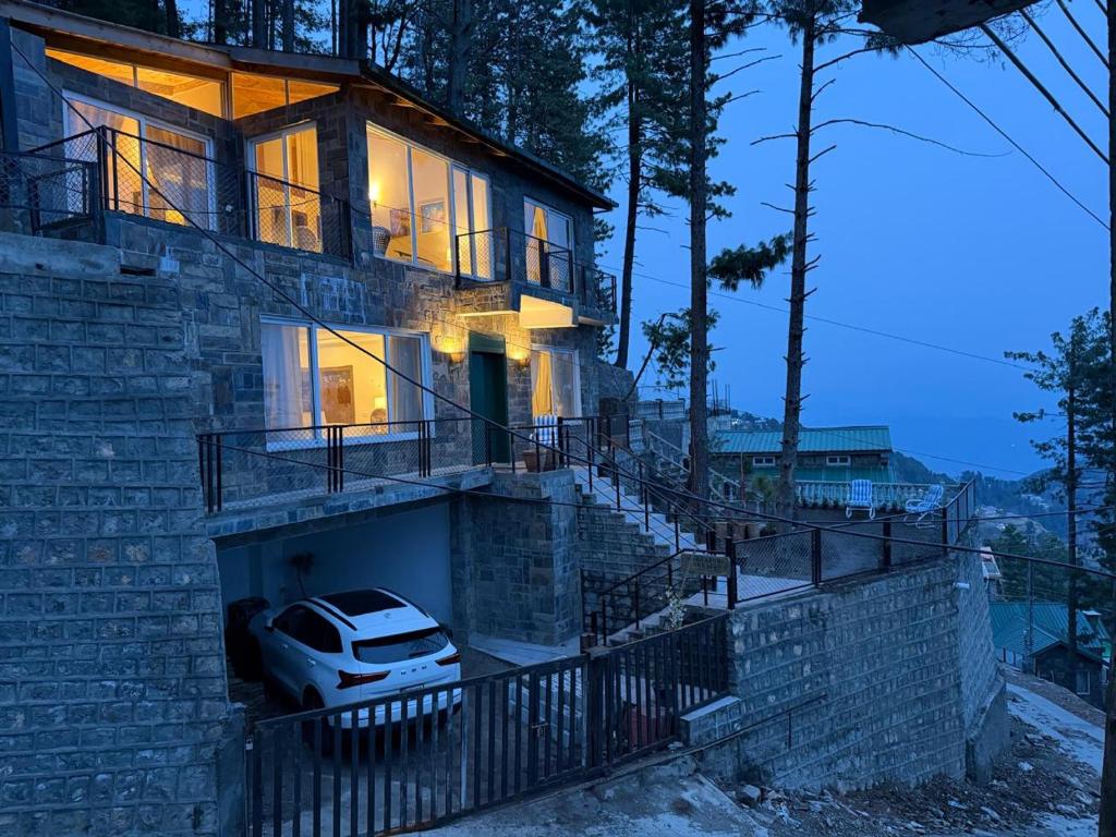 a house with a car parked in front of it at Haven Mushkpuri Terraces Khaira Gali - 3BR Home, Lawn, BBQ & Fireplace in Chhāngla Gali