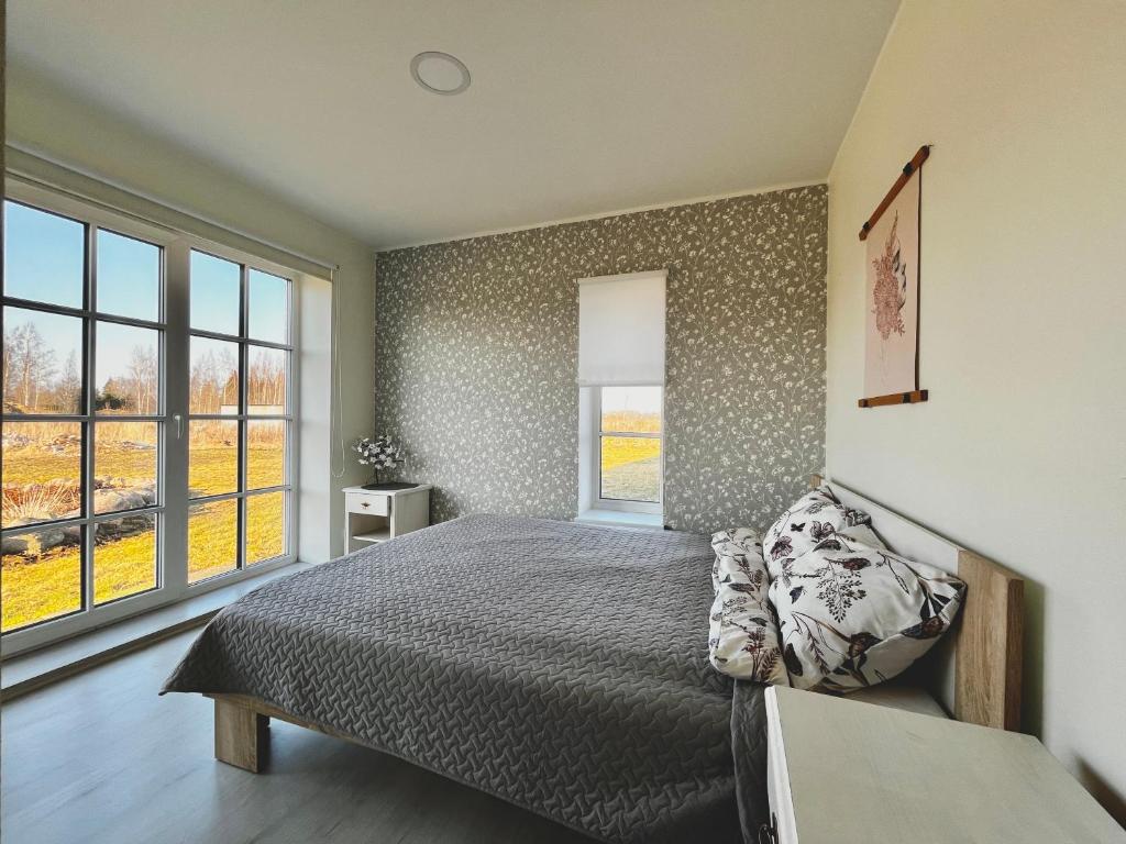a bedroom with a bed and a large window at Vahtralehe majutus in Tartu