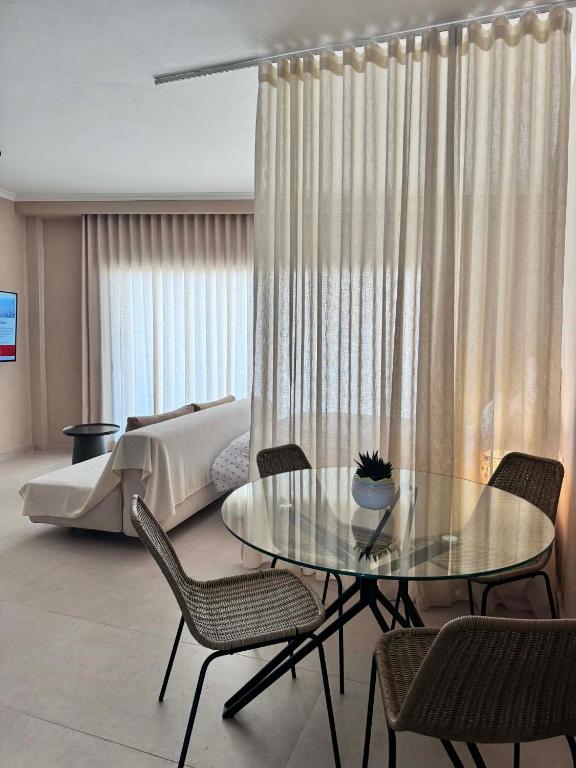 a bedroom with a bed and a glass table and chairs at Nest Studio in Katerini
