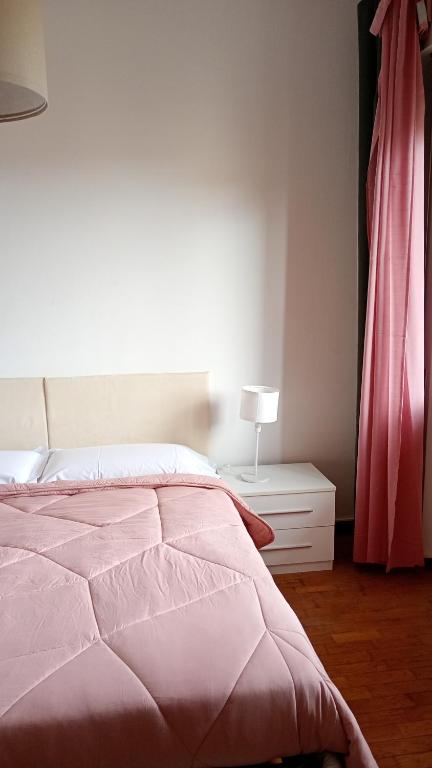 a bedroom with a bed and a dresser with a lamp at Home in Arezzo