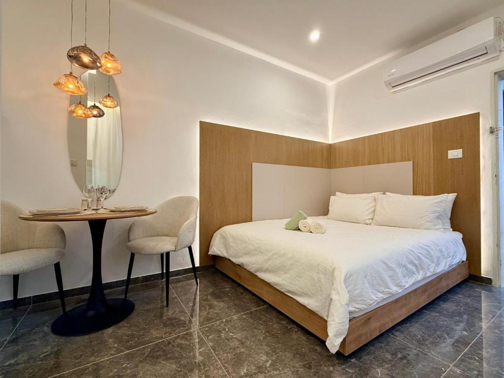 a bedroom with a bed and a table and chairs at Pure Sense in Beʼer Ora