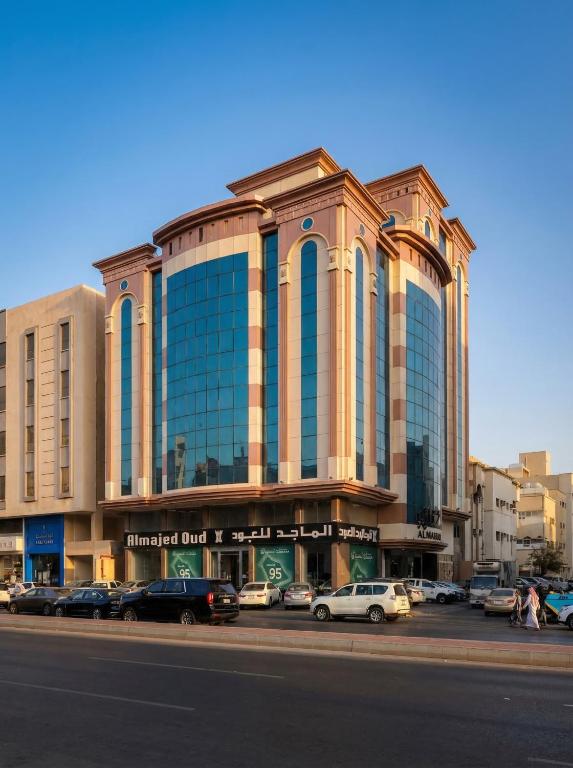 a large building with cars parked in a parking lot at Al Muhajir Serviced Apartments Quraish Branch in Jeddah