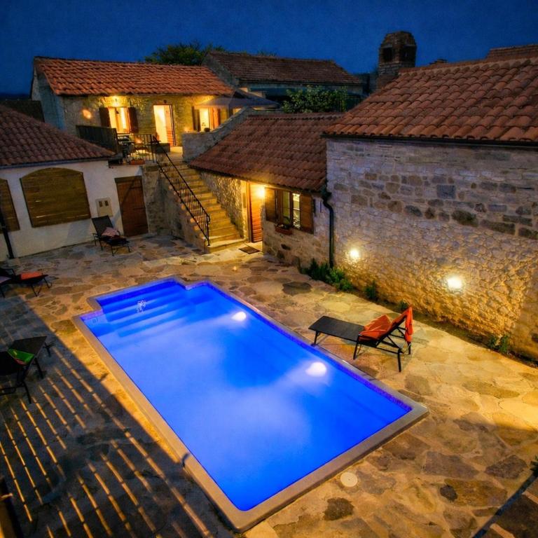 a swimming pool in front of a house at night at Holiday home Dida Jere in Benkovac