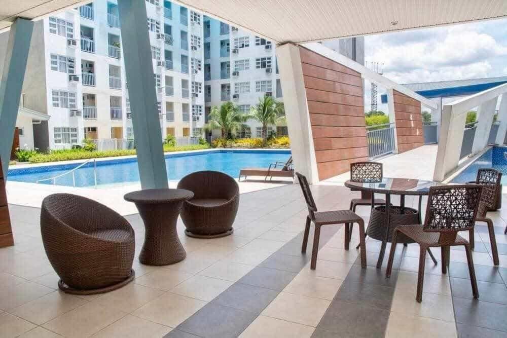 a patio with a table and chairs and a pool at Dysha's Home in Davao City