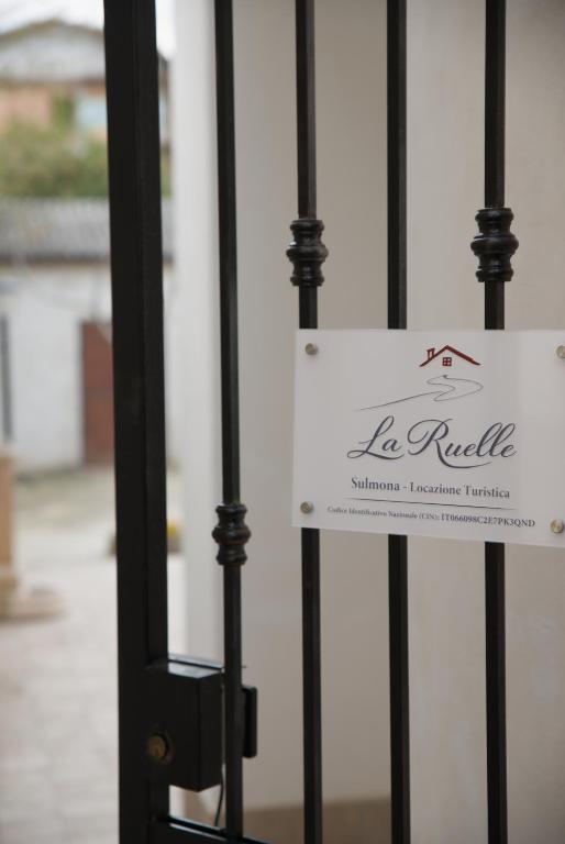 a sign on a gate in front of a building at La Ruelle in Sulmona
