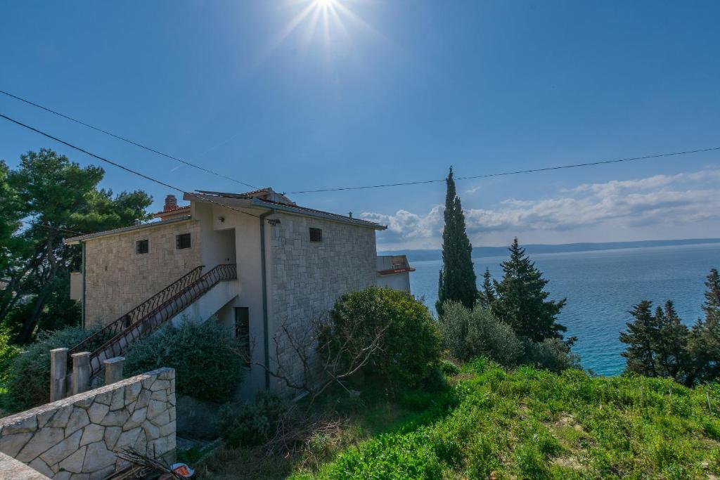 a house on a hill with a view of the ocean at Apartments Blue Adriatic View in Jesenice