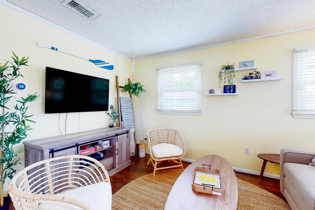 a living room with a flat screen tv at Salty Tails in Kill Devil Hills