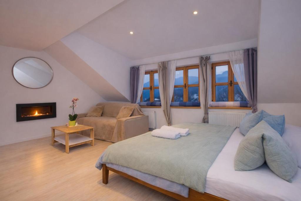 a bedroom with a bed and a couch and a fireplace at Penzion Quest in Loket