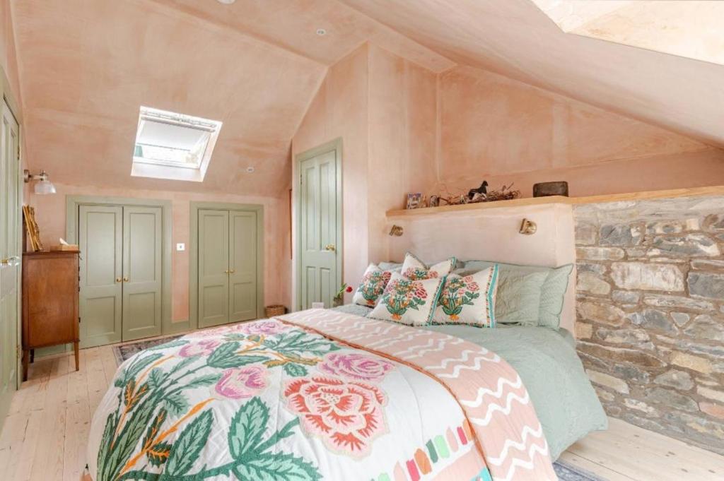 a bedroom with a bed and a stone wall at The Wood Wing Suite at Bellspool in Peebles